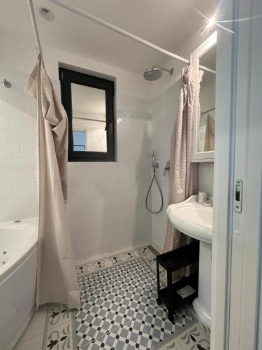 a bathroom with a tub and a sink and a mirror at Apartment DB in Split