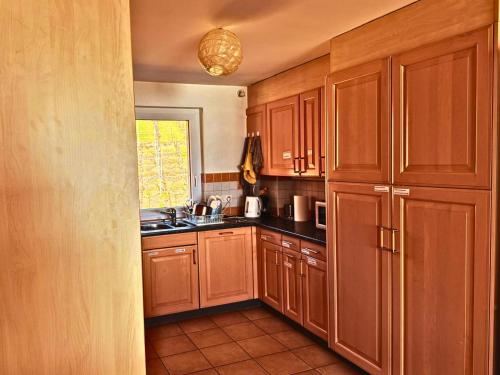 a kitchen with wooden cabinets and a sink at Lavaux nice place in Swiss French part in Rivaz