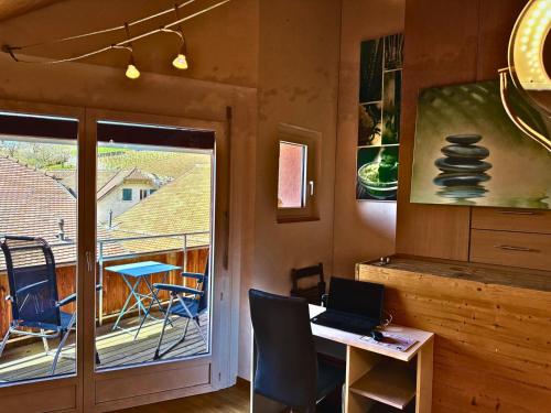 a room with a desk with a laptop and a balcony at Lavaux nice place in Swiss French part in Rivaz