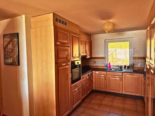 a kitchen with wooden cabinets and a sink and a window at Lavaux nice place in Swiss French part in Rivaz