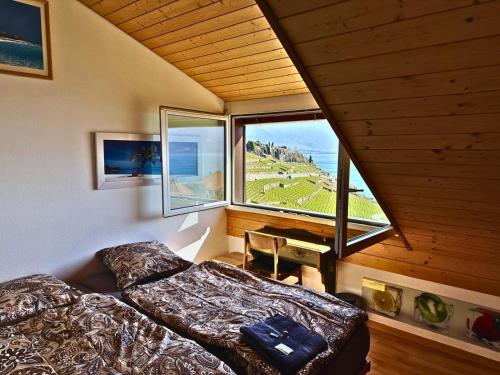 a bedroom with a bed and a large window at Lavaux nice place in Swiss French part in Rivaz