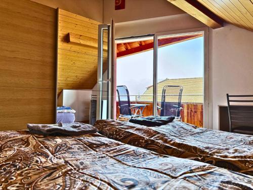 two beds in a room with a large window at Lavaux nice place in Swiss French part in Rivaz