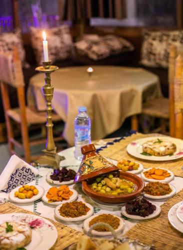 a table with plates of food and a candle at Riad Tarab Fes in Fès