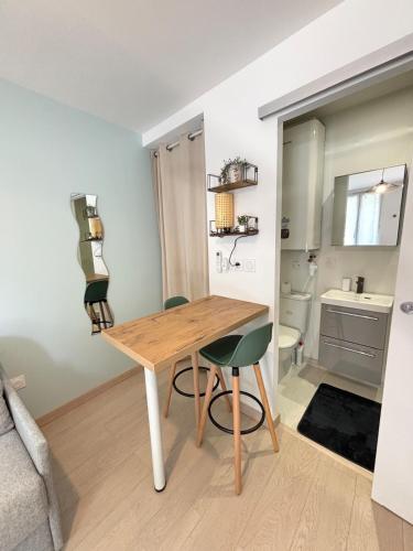 une chambre avec une table en bois et deux chaises dans l'établissement Studio l'Azur - Garage & Clim - Valence, à Valence
