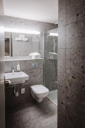 a bathroom with a toilet and a sink and a shower at Holiday Inn Hotel Brussels Airport by IHG in Diegem