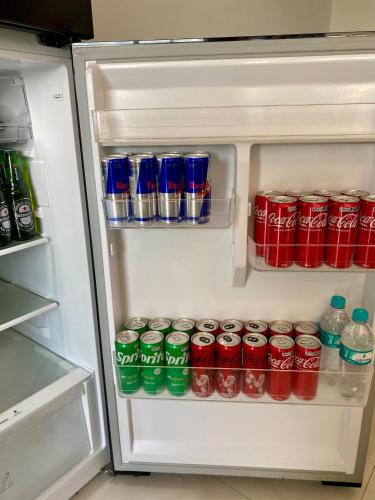an open refrigerator filled with soda cans and sodas at casa grande e confortavel in Sinop