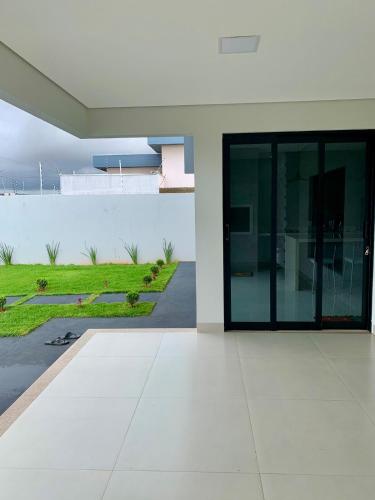 a white house with a large glass door at casa grande e confortavel in Sinop