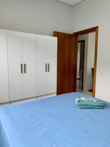 a bedroom with a blue bed and white cabinets at casa grande e confortavel in Sinop