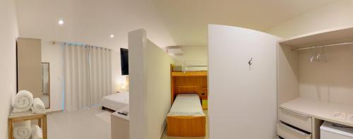 a small room with a bedroom with a bed and a kitchen at Villa Paririö in Canoa Quebrada