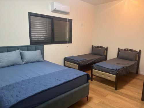 a bedroom with two beds and a bed and a chair at Royal villa Nazareth in Nazareth