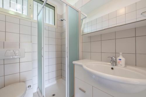 ein weißes Badezimmer mit Waschbecken und Dusche in der Unterkunft Appartamento Lago Blu in Manerba del Garda