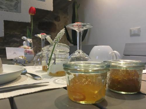 a table topped with jars of honey and flowers at B&B Il Piccolo Principe room and breakfast in Bieno