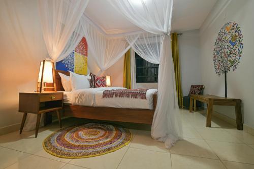 a bedroom with a canopy bed and a window at Aqueduct 1359 Hotel Apartments in Kampala