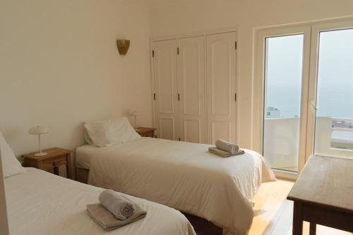 a bedroom with two beds with towels on them at Casa Isa Bela in Buarcos