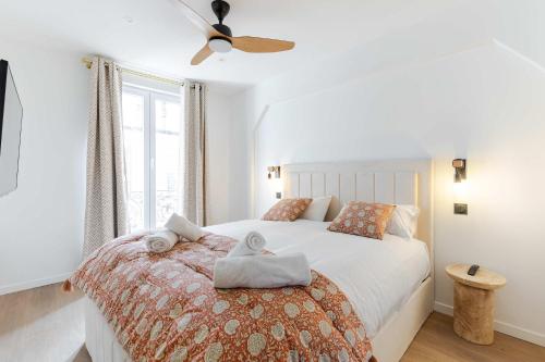 une chambre blanche avec un lit avec des serviettes dessus dans l'établissement New- 8 pers devant le parc de la villette, à Paris