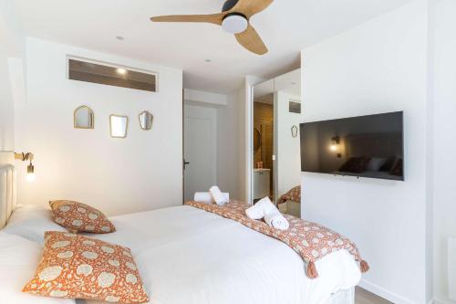 a bedroom with a white bed with a ceiling fan at New- 8 pers devant le parc de la villette in Paris