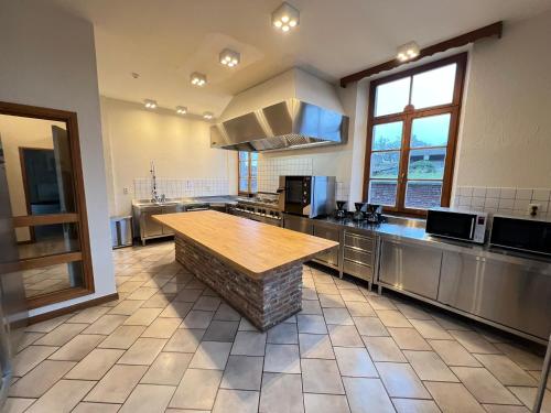 a large kitchen with a wooden table in it at La Recreation in Somme-Leuze