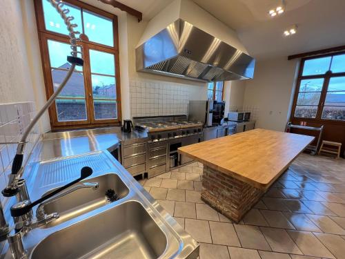 a kitchen with a sink and a wooden table at La Recreation in Somme-Leuze