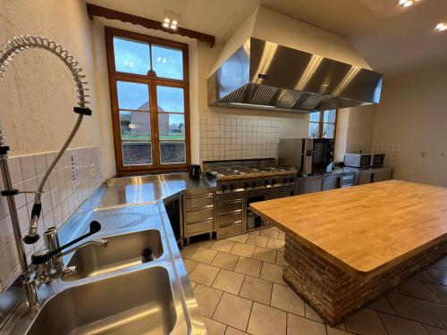 a large kitchen with a sink and a counter at La Recreation in Somme-Leuze