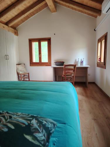 a bedroom with a green bed and a desk at La Caneveta al Piave in Valdobbiadene