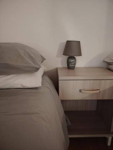 a bed with a night stand with a lamp on it at La Caneveta al Piave in Valdobbiadene