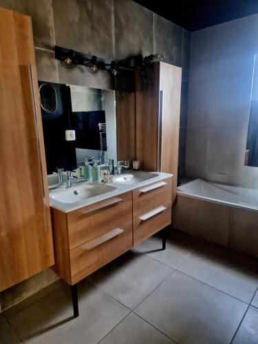 une salle de bain avec un lavabo, une baignoire et un miroir dans l'établissement Wonderful Villa , swimming pool, air conditionner-4 chambres, à Cuers