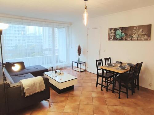 un salon avec un canapé et une table dans l'établissement Grand T2 central, balcons sur parc, à Villeurbanne
