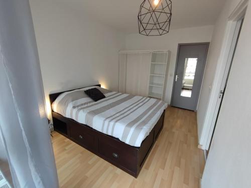 une chambre avec un lit dans une pièce blanche dans l'établissement Grand T2 central, balcons sur parc, à Villeurbanne