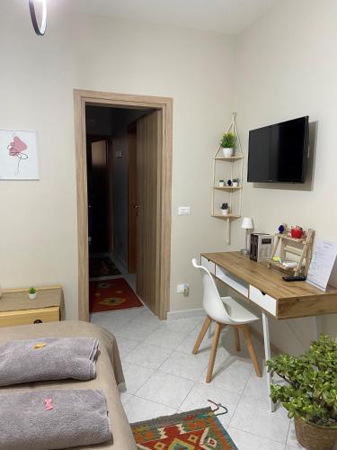 a room with a desk and a television and a bedroom at La casa di Angela in Monreale
