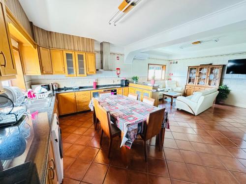 a kitchen with a table and a dining room at A Casa dos Sonhos in Chaves
