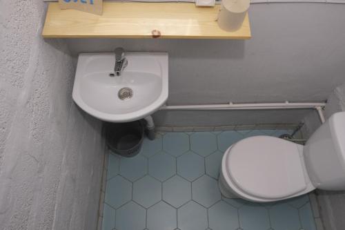 a bathroom with a white toilet and a sink at Tumanyan Bathhouse Hostel in Tʼumanyan
