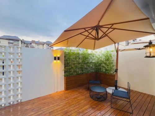 a patio with an umbrella and chairs on a deck at Magnotel Guilin Elephant Trunk Hill in Guilin