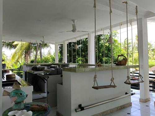 a kitchen with white walls and a counter with swings at Skylodge B&B - Bali Jungle Retreat with Fine Dining & Eco Pool in Bukti