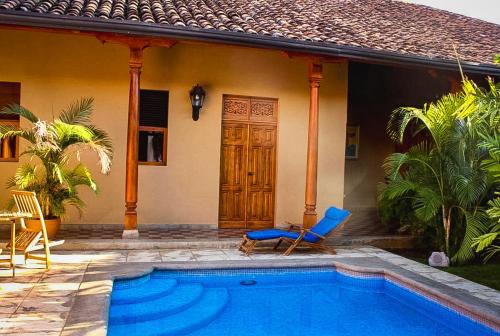 a house with a swimming pool in front of a house at Hotel Colonial Victonella in Granada