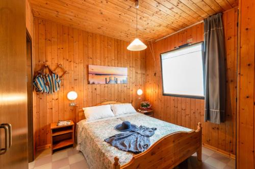 a bedroom with a bed in a wooden room at Villaggio California in Eraclea Mare