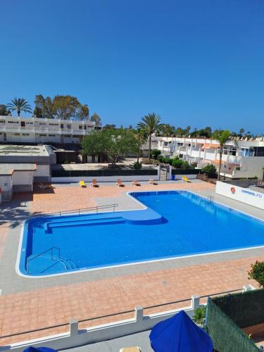 een groot zwembad in een resort bij EL CHAPARRAL Studio-appartement with fantastic pool- view and STRONG WIFI in Costa Del Silencio