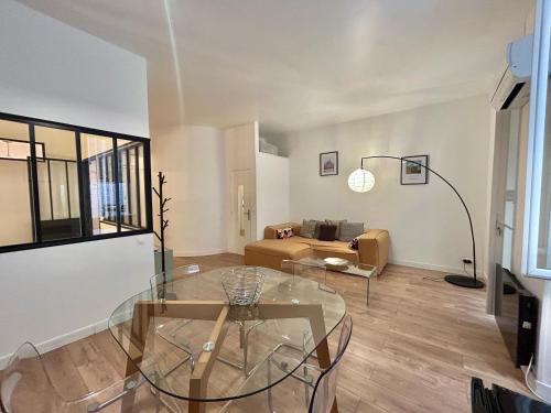un salon avec une table en verre et un canapé dans l'établissement Chez Marie et Romain- appartement de charme au cœur de la Joliette proche Panier centre ville, à Marseille