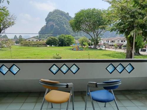 a balcony with two chairs and a view of a park at Grey Fantasy Homes#Sunway Water Theme Park in Ipoh