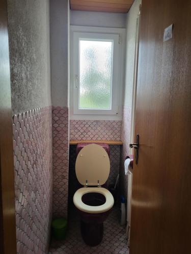 a small bathroom with a toilet and a window at Double Bedroom with Balcony in Lenzburg