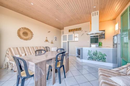 une cuisine et une salle à manger avec une table et des chaises dans l'établissement Vu Mer T2 plage centrale 6 personnes, à Soulac-sur-Mer