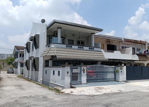 a white house with a gate in front of it at Grey Fantasy Homes#Sunway Water Theme Park in Ipoh
