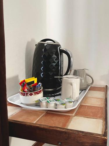 a tray with a tea kettle and cups on a table at Old Palace Guest House in Brighton & Hove