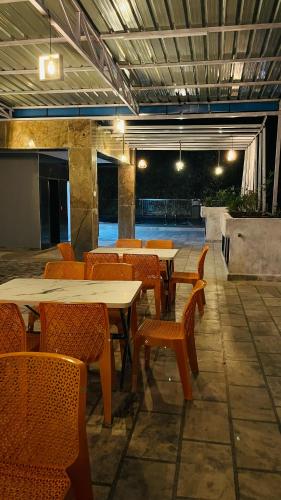 a restaurant with tables and chairs and a tennis court at Shri Shyam Hotel, Near Harkipauri in Haridwār