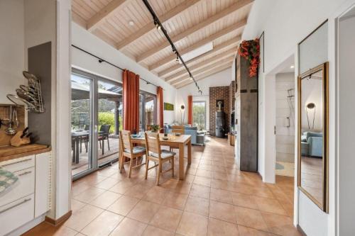 eine Küche und ein Esszimmer mit Tisch und Stühlen in der Unterkunft PINTO ROSSO - rotes Strandhaus an idyllischem Privatsee in Twist
