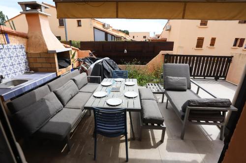 un patio avec une table et des chaises sur un balcon dans l'établissement Maison dans résidence avec piscine 3 Chambres, à Saint-Cyprien