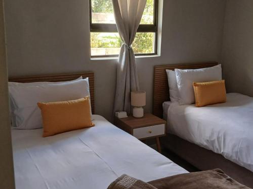 a bedroom with two beds and a window at Ledges Retreat in Bergville