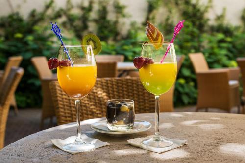 two glasses of orange juice and grapes on a table at Hôtel Magellan in Paris