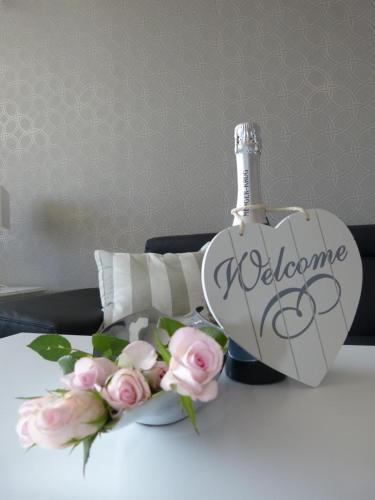 a bottle of champagne and flowers on a bed at Haus Käptn Christiansen 46 in Westerland