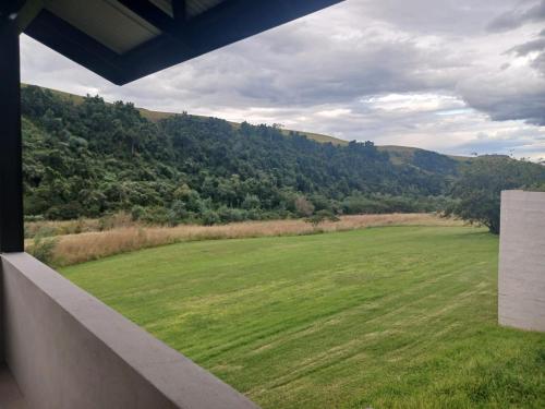 a view of a green field from a balcony at Ledges Retreat in Bergville