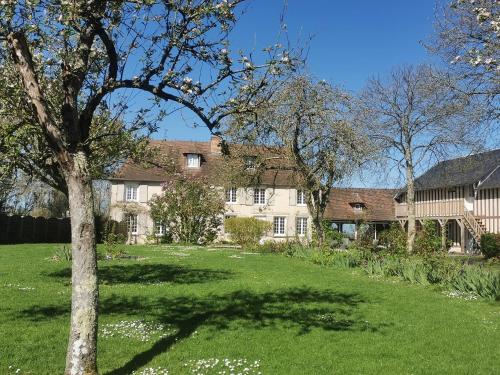 a large house with a green yard with a tree at les marronniers in Cambremer
